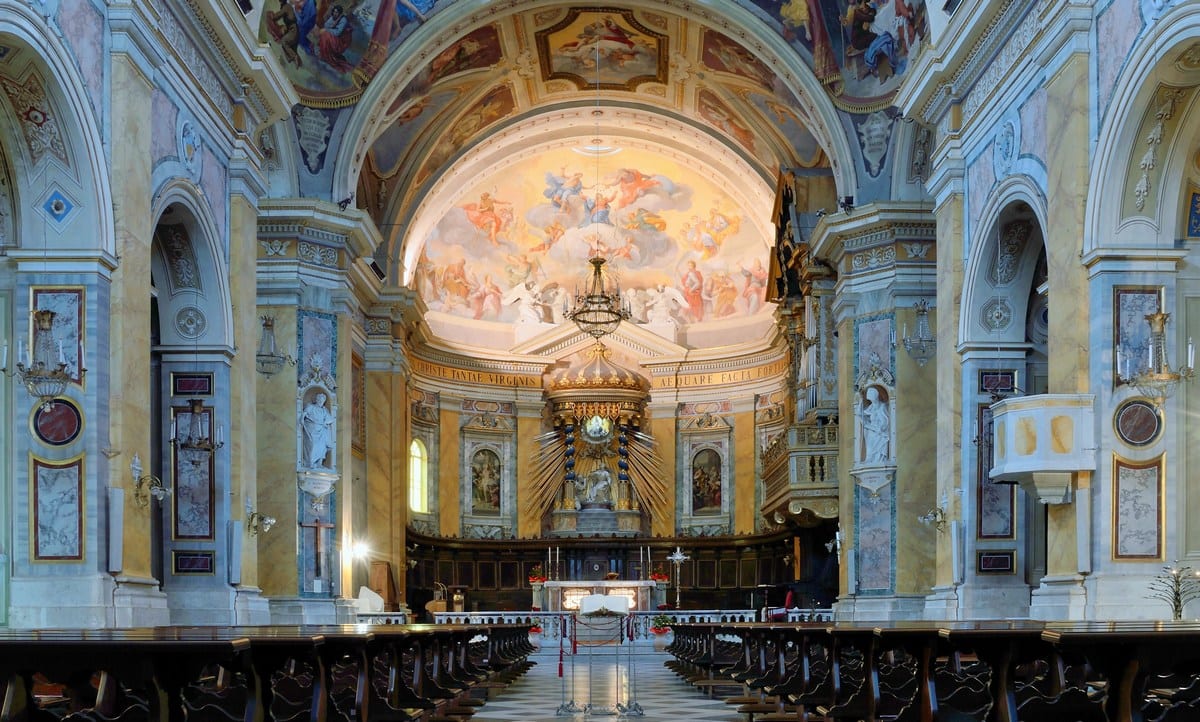 Interno della cattedrale di Amelia illuminato dalla luce naturale, con architettura maestosa e decorazioni eleganti.